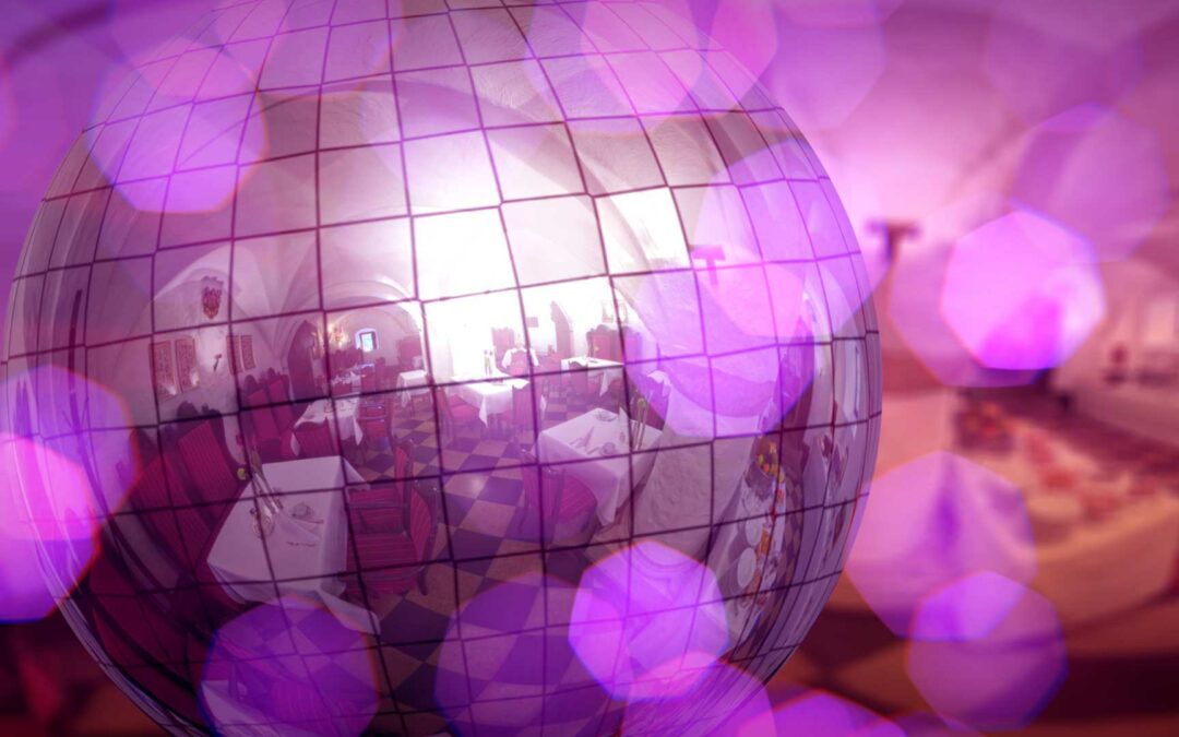 Spiegelnde Discokugel in einem Raum mit Tischen und Stühlen